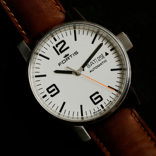 a close up of a watch on a black surface