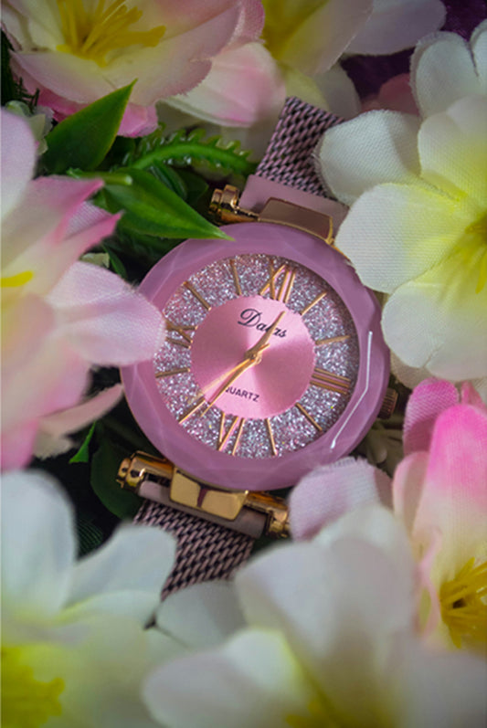 a pink watch surrounded by pink and white flowers