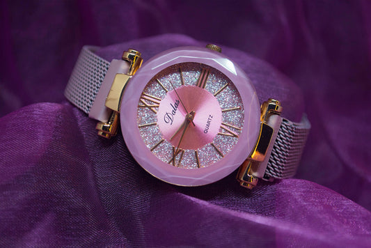 a close up of a watch on a purple cloth
