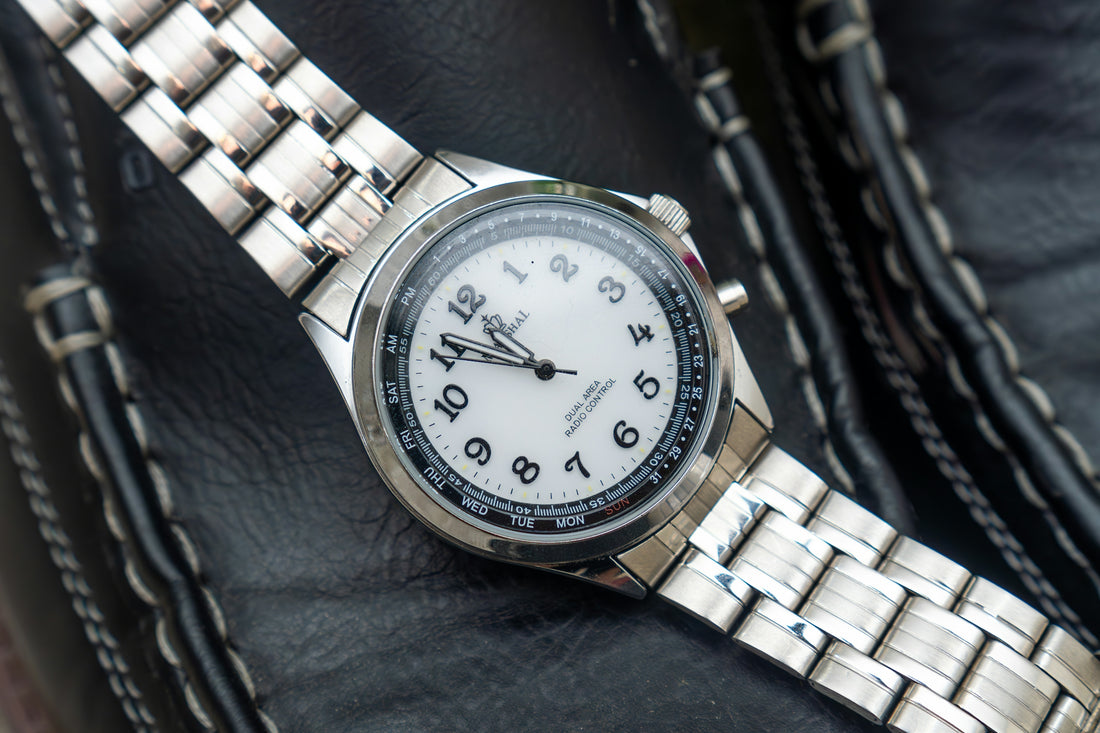 a close up of a watch on a black leather surface