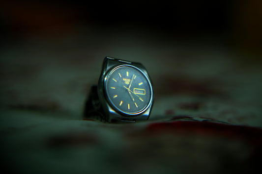 A watch sitting on the ground in the dark