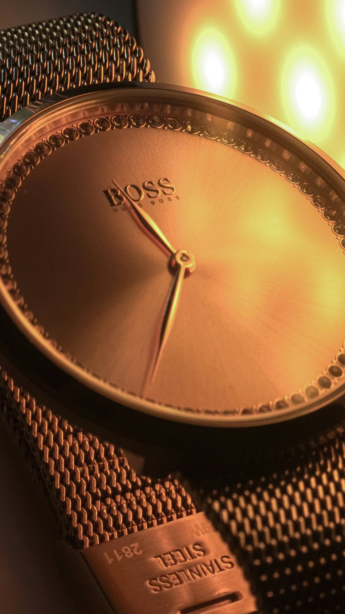 Close-up of a rose gold boss watch with mesh strap